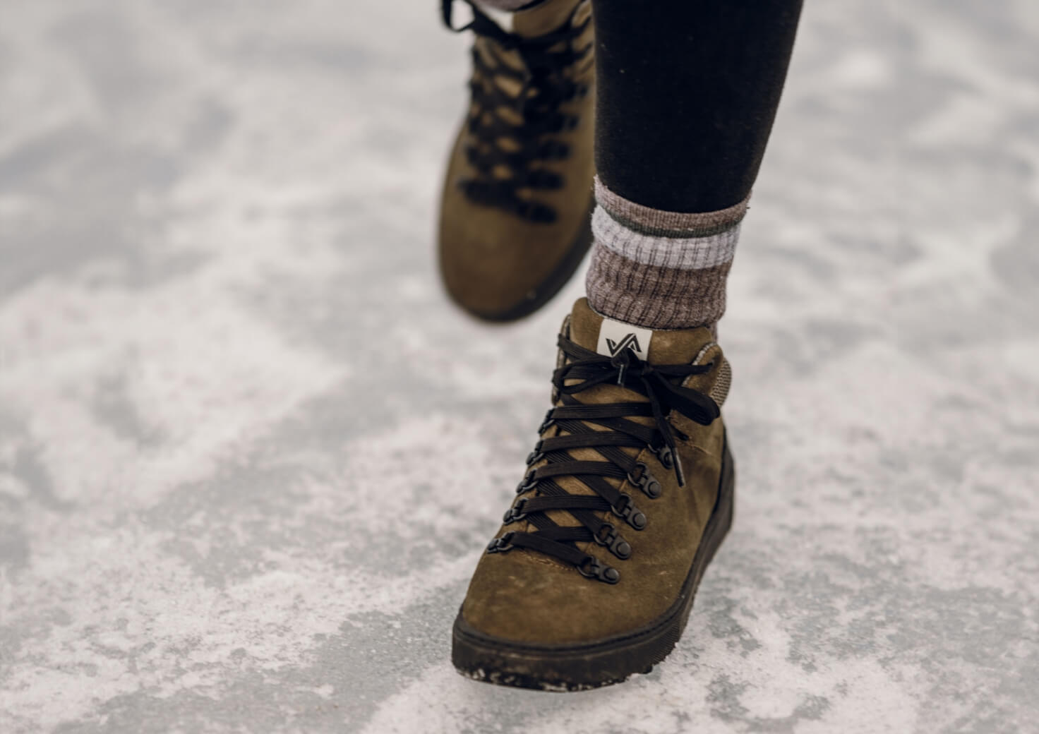 Shop Forsake Women's featuring the Lucie Mid in olive walking in the snow.